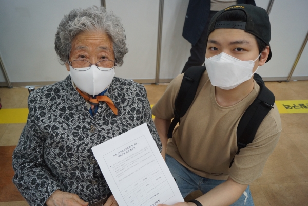손자 이도현 씨와 함께 예방접종을 하러 나온 박덕희(85) 여사다. 백신 접종 후 증명서를 보이고 있다.