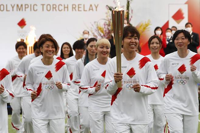 25일 일본 후쿠시마현 나라하에서 2020 도쿄올림픽 성화 봉송이 시작돼 2011년 당시 일본 여자축구 국가대표팀 '나데시코 재팬' 멤버들이 성화 봉송을 하고 있다. 성화 봉송은 도쿄올림픽 개막식이 열리는 7월23일까지 121일 동안 일본 전역을 돌면서 진행된다. 2021.03.25./사진=[나라하=AP/뉴시스]