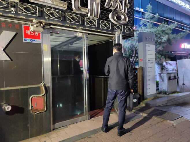 연합뉴스 제공 - 9일 새벽 경기 성남 분당구 유흥업소 밀집지역에서 경찰관이 영업 중인지 확인하고 있다.