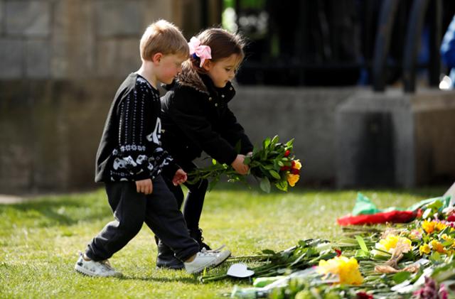 영국 어린이들이 9일 별세한 필립공을 추모하기 위해 윈저성 앞에 꽃을 놓고 있다. 윈저=로이터 연합뉴스