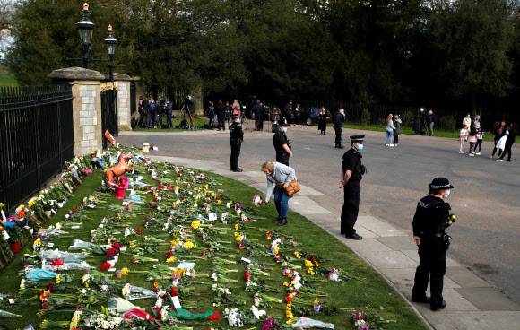영국 경찰이 9일 99세를 일기로 세상을 떠난 엘리자베스 2세 여왕의 남편인 필립 공이 영면에 든 런던 근처 윈저궁에 너무 많은 헌화객이 몰리지 않도록 살펴보고 있다.윈저 로이터 연합뉴스