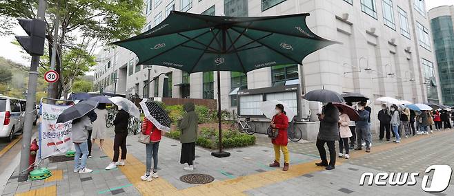 12일 서울 중랑구 보건소에 마련된 선별진료소를 찾은 시민들이 신종 코로나 바이러스 감염증(코로나19) 검사를 받기 위해 줄지어 기다리고 있다. 중앙방역대책본부는 이날 0시 기준으로 코로나19 신규 확진자가 587명 늘어 누적 11만146명이라고 밝혔다. 2021.4.12/뉴스1 © News1 박지혜 기자