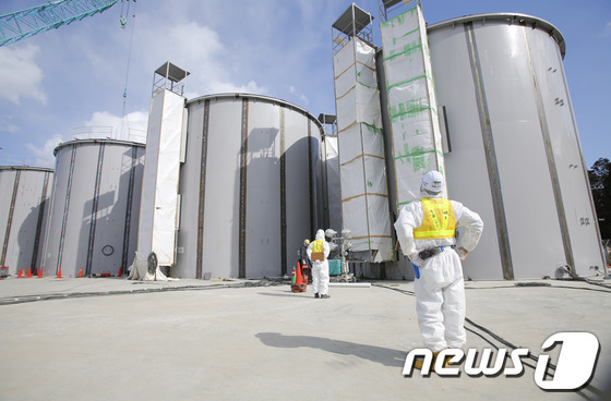 후쿠시마 원전 근로자가 오염수 저장탱크를 바라보고 있다. © AFP=News1