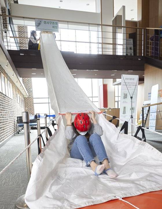 화재 시 계단으로 대피할 수 없을 때 여러 사람이 한꺼번에 이동할 수 있는 피난기구 경사구조대 체험을 한 윤시현 학생기자.