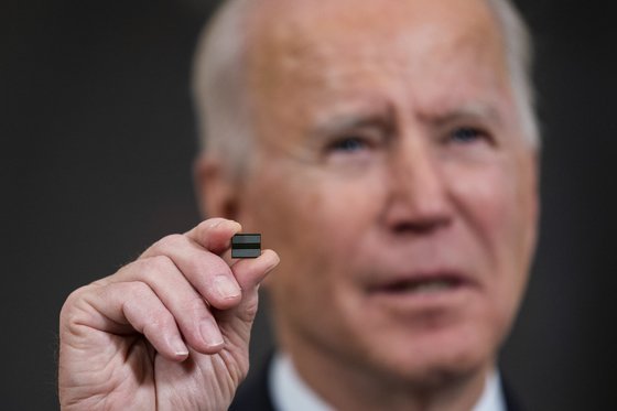 미국의 조 바이든 대통령이 지난 2월 백악관에서 반도체·전기차배터리·희토류 등 주요 물자의 공급망 점검을 지시하는 행정명령에 서명하기 전 반도체 칩을 들어 보이고 있다. [EPA]