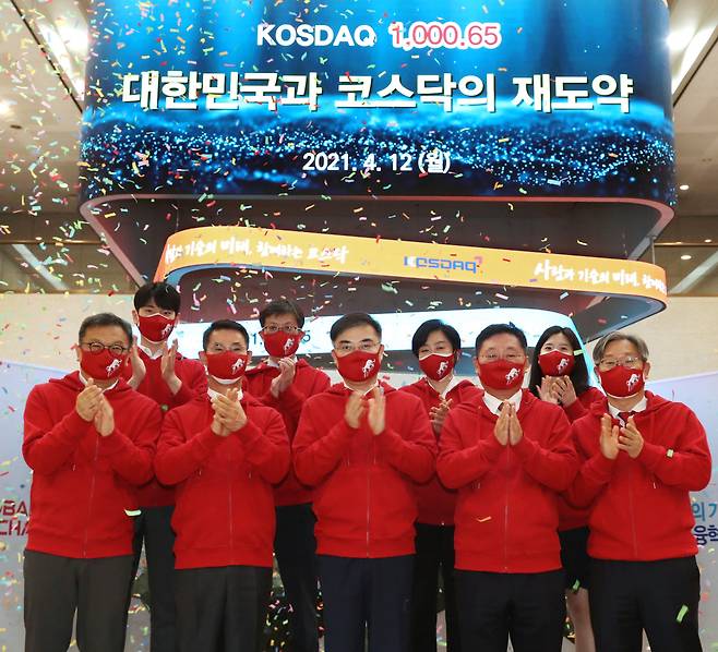Kosdaq Listed Companies Association Chairman Chang Kyeong-ho (front row, second from left), Korea Exchange Chairman Sohn Byung-doo (front row, center), Korea Financial Investment Association Chairman Na Jae-chul (front row, fourth from left) and officials from the market operator celebrate South Korea’s tech-heavy Kosdaq’s closing above 1,000 points for the first time since Sept. 2000 at Korea Exchange’s Seoul office on Monday. (KRX)
