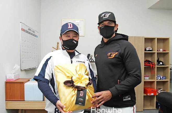 카를로스 수베로 한화 감독(오른쪽)이 지난 9일 대전구장에서 원정 팀 김태형 두산 감독에게 인삼 세트를 선물하고 있다. 한화 이글스 제공