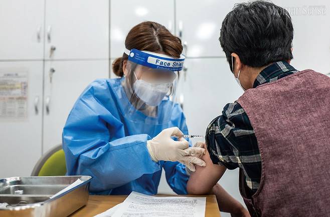 전국적으로 코로나19 백신 접종이 시작된 지난 2월 26일 오전 서울 성동구보건소에서, 노인요양시설 요양보호사가 아스트라제네카 백신을 접종 받고 있다.(사진 공동취재단)