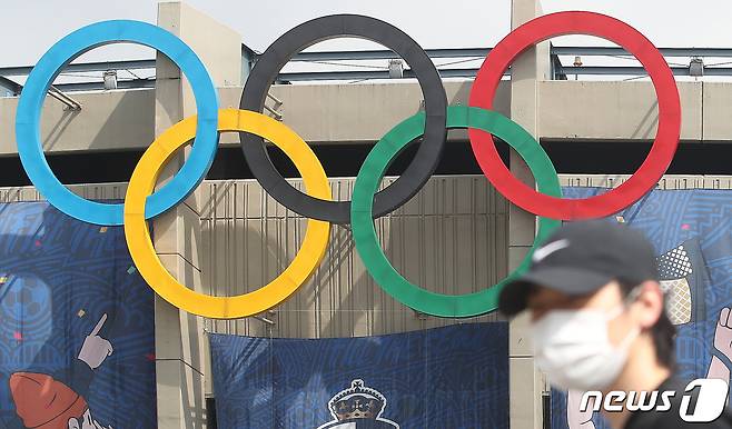 도쿄올림픽 개최를 100여일 앞두고 있는 13일 서울 송파구 잠실주경기장 오륜마크 앞으로 시민들이 지나고 있다. 교도통신에 따르면 지난달 10~12일 실시된 여론조사에서 일본 국민의 70% 이상이 올림픽 취소나 연기를 바란다는 조사 결과 나왔다. 응답자의 39.2%가 올림픽 취소를, 32.8%는 연기를 지지했다. 올림픽을 예정대로 진행해야 한다는 응답자는 24.5%에 불과했다. 이 같은 조사 결과는 최근 들어 일본 국민들 사이에서 코로나19 바이러스 확산 우려가 점점 더 높아지고 있음을 나타낸다. 2021.4.13/뉴스1 © News1 임세영 기자