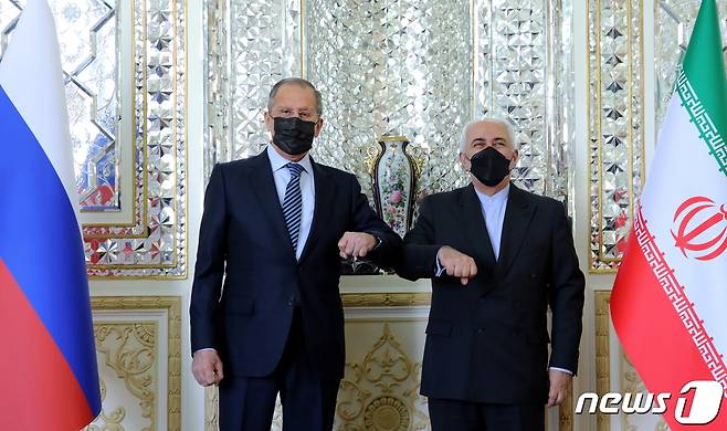 13일 테헤란에서 모하마드 자바드 자리프 이란 외무장관과 세르게이 라브로프 러시아 외무장관이 팔꿈치 인사를 하고 있다. © 로이터=뉴스1