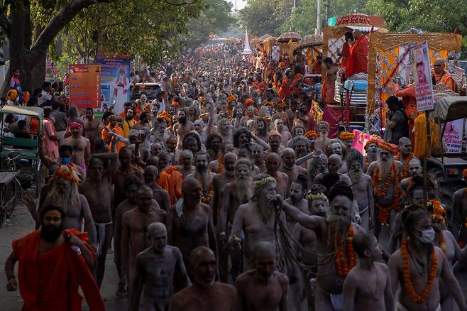 인도가 코로나 바이러스 감염증 폭증으로 비상인 가운데 12일(현지 시각) 힌두교 최대 축제인 '쿰브멜라'에 참가한 사두(힌두교 성자)와 신도들이 목욕 의식을 위해 갠지스강으로 행렬을 지어 가고 있다. /연합뉴스