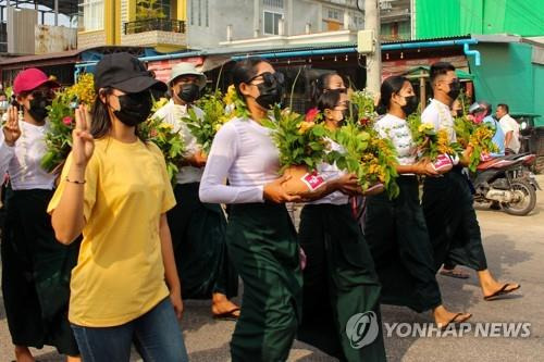 다웨이에서 띤잔 축제 꽃이 든 화분을 들고 세손가락 경례를 하며 행진하는 여성들 [다웨이 워치/AFP=연합뉴스. 재판매 및 DB 금지]