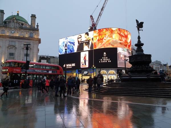 휘황찬란한 네온사인으로 가득한 피카딜리 서커스 주변의 대형 전광판과 런던의 상징인 빨간 2층 버스.