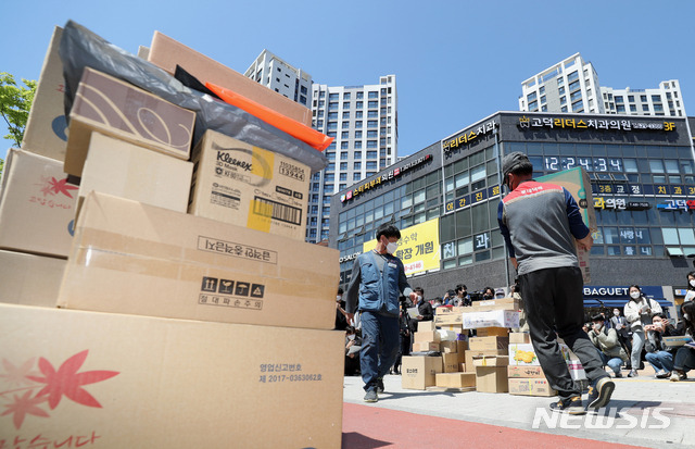 [서울=뉴시스]이윤청 기자 = 전국택배노동조합 조합원들이 14일 서울 강동구 고덕동의 한 아파트단지 입구에 택배물품을 내리고 있다. 총 5000세대 규모로 알려진 해당 아파트는 안전 사고 및 시설물 훼손 우려를 이유로 지난 1일부터 모든 차량이 지하주차장을 통해 이동하도록 했다. 하지만 대부분 택배차량은 지하주차장 진입제한 높이(2.3m)보다 차체가 높아 진입이 불가능하다. 2021.04.14. radiohead@newsis.com