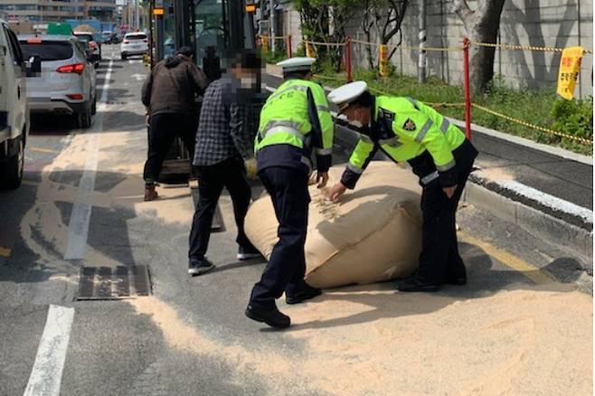 부산 한 도로에 벼 껍데기와 겨가 쏟아져 경찰이 출동했다. 부산경찰청 제공