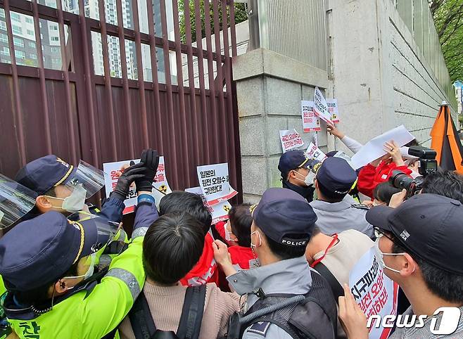 진보당 부산시당이 15일 오후 동구 일본영사관 벽에 항의 스티커를 부착하고 있다. 이 과정에서 경찰과의 물리적 충돌이 빚어지기도 했다.2021.4.15/© 뉴스1 노경민 기자