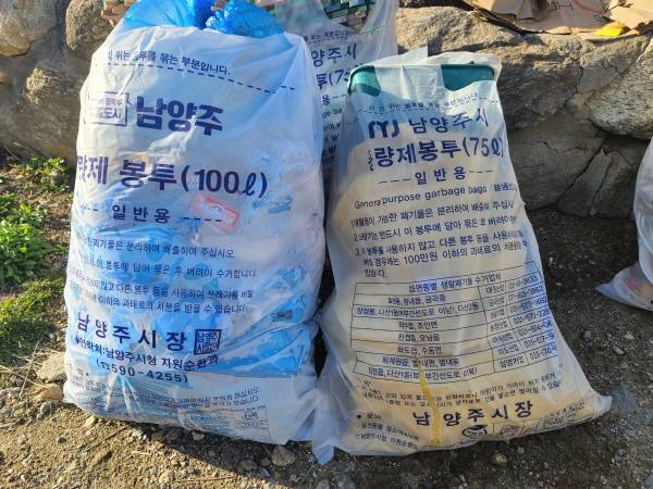 75리터 종량제 봉투에 청테이프를 이용해 100L 종량제 봉투와 크기가 비슷하게 쓰레기가 담겨져 있다.