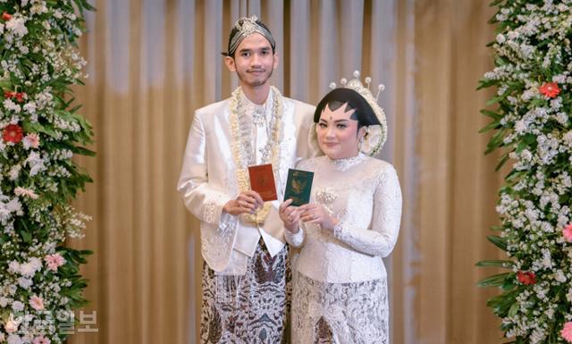 인도네시아 신랑 신부가 '이자브 카불'을 마친 뒤 혼인증명서를 보여주고 있다. 데폭=고찬유 특파원