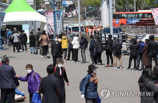 지난 14일 오후 서울역광장에 마련된 임시선별진료소에서 시민들이 검사를 받기 위해 줄을 서고 있다. [연합뉴스 자료사진]