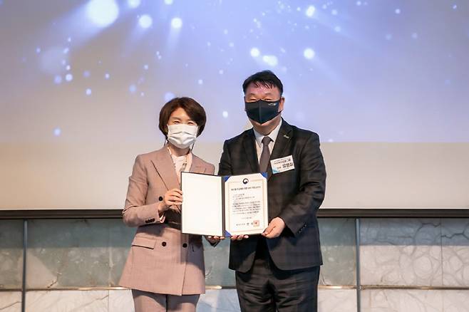 유병철 OK저축은행 전무(오른쪽)가 한정애 환경부 장관으로부터 14일 서울 중구 플라자 호텔 서울에서 열린 `2030 한국형 무공해차 전환100(K-EV100)` 선언식에서 지정서를 수여 받고 있다. [사진 제공 = OK금융그룹]