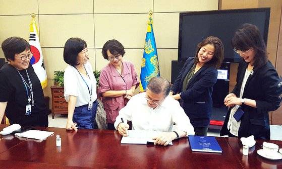 문재인 대통령이 청와대 여성 비서관들과 오찬을 함께 한 뒤 대통령 취임 1주년을 맞아 발간된 영문 연설집에 서명하고 있다. 왼쪽부터 신미숙 전 균형인사비서관, 김혜애 전 기후환경비서관, 엄규숙 전 여성가족비서관, 문 대통령, 정혜승 전 디지털소통센터장, 신지연 현 제1부속비서관(당시 해외언론비서관) [사진제공=청와대]