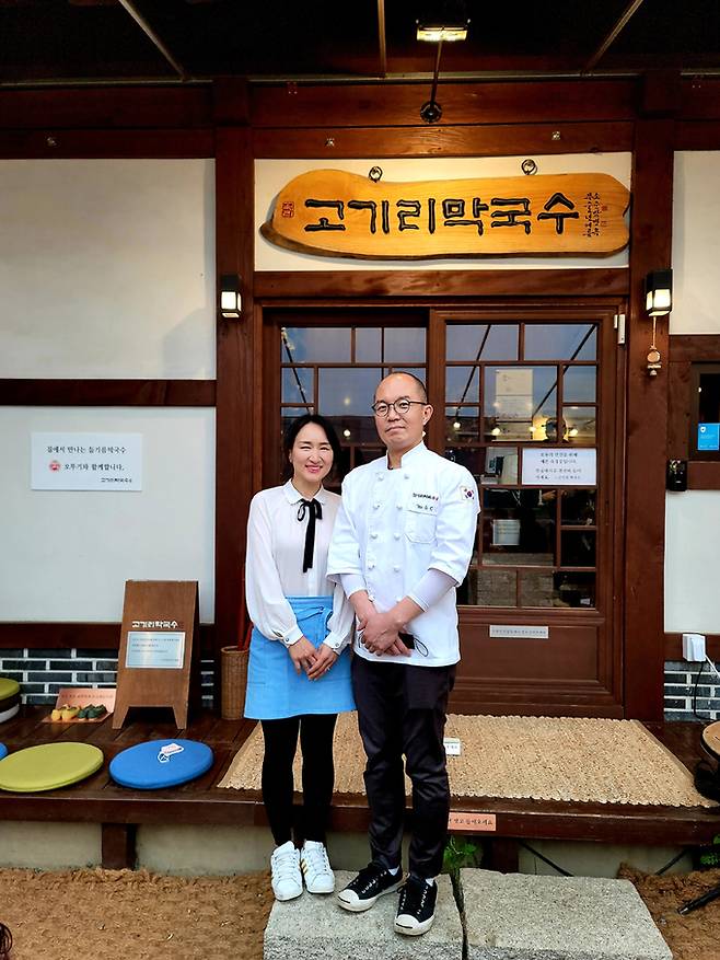 코로나19에도 하루 손님 1000명이 찾아 ‘장사의 신’에 등극한 경기도 용인시 수지구 고기리막국수 김윤정 대표(왼쪽)와 유수창 셰프 부부가 지난 12일 고기리막국수 앞에서 포즈를 취하고 있다. 김 대표는 작은가게는 손님을 대하는 진심과 맛을 개선하려는 끊임없는 노력이 중요하다고 강조한다.