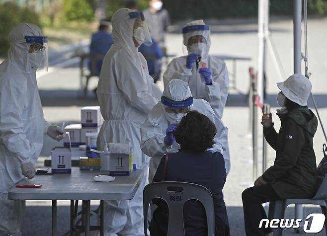 19일 오전 울산 남구 문수축구경기장 대형버스 정류장에 마련된 신종 코로나바이러스 감염증(코로나19) 임시 선별검사소를 찾은 시민들이 검사를 받고 있다. 울산시는 코로나19 확산세가 지속 됨에 따라 이날부터 남구 문수축구경기장, 중구 종합운동장, 울주군 범서생활체육공원 등 3곳에 코로나19 임시 무료 선별검사소를 설치해 운영한다. 2021.4.19/뉴스1 © News1 윤일지 기자