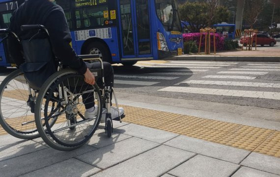 '장애인의 날'을 하루 앞둔 19일 휠체어를 이용해 보행로를 이동해봤다. 보행로는 움푹 파이거나 고르지 못하고 횡단보도에는 자동차 진입 억제용 말뚝으로 불편이 심했다.