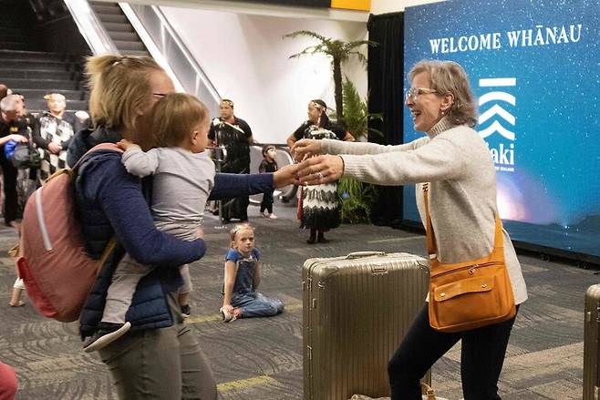 오스트레일리아와 뉴질랜드가 양국 간 자유여행을 허용한 19일 아침 시드니발 첫 항공기로 뉴질랜드 웰링턴 공항에 도착한 여행객이 가족과 재회의 기쁨을 만끽하고 있다. 웰링턴/AFP 연합뉴스 
