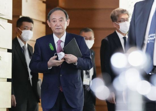 스가 요시히데(菅義偉) 일본 총리가 19일 오전 일본 총리관저에서 기자들의 취재에 응하기 위해 마스크를 벗고 이동하고 있다. [이미지출처=연합뉴스]