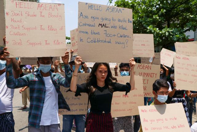 20일 미얀마 양곤 시민들이 쿠데타 주역 민 아웅 흘라잉 최고사령관의 아세안 정상회의 참석을 반대하는 피켓을 들고 있다. 양곤=AP 연합뉴스