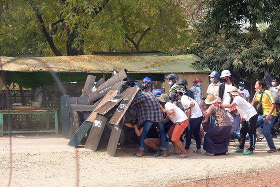 지난달 7일 미얀마 냥우에서 시위대가 군경의 진압에 맞서 방패로 몸을 보호하고 있다. 미얀마에서는 군경 진압으로 48명 이상이 숨졌다. [로이터]