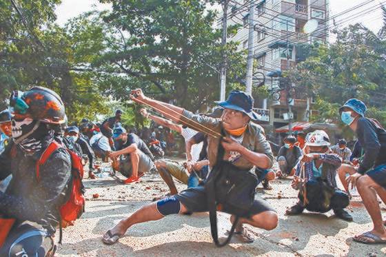 군부 쿠데타에 항의하는 미얀마 시민들이 지난 28일 최대 도시 양곤에서 실탄 사격을 하는 경찰에 새총으로 대응하고 있다. [AP=연합뉴스]
