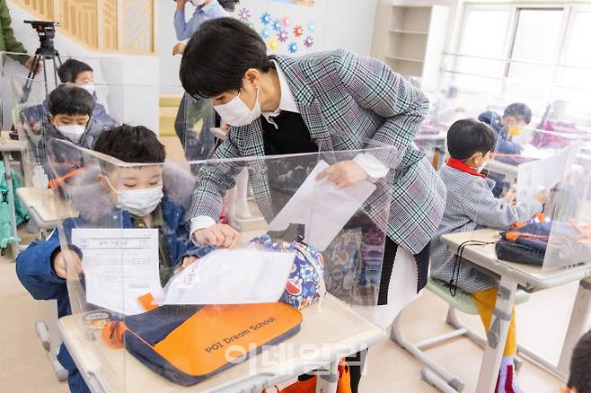 지난달 2일 오전 서울시 강남구 포이초등학교에서 첫 등교를 한 1학년 학생들이 담임교사로 부터 알림장을 받고 있다.(사진=뉴시스)