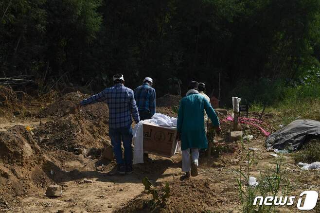 인도 뉴델리의 한 묘지에서 코로나19로 인한 사망자를 올기고 있다.© AFP=뉴스1