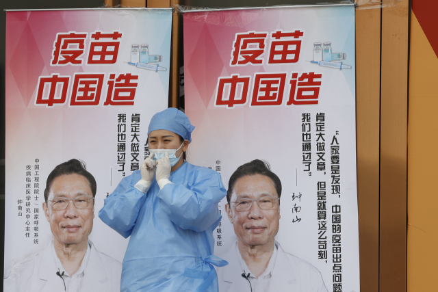 중국의 ‘백신 영웅’이라는 중난산 박사 사진이 들어있는 중국산 코로나19 백신 홍보 포스터가 베이징의 한 접종소에 내걸려있다. /AP연합뉴스