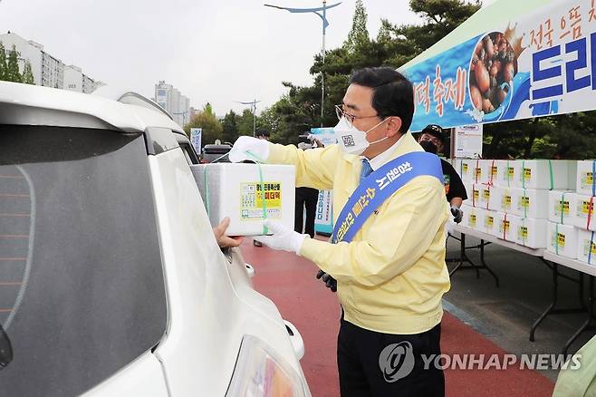 '진동 미더덕' 맛보세요 (창원=연합뉴스) 경남 창원시가 22일 창원스포츠파크 만남의 광장에서 제철을 맞은 지역 특산물 '진동 미더덕'을 비대면(드라이브 스루)으로 판매했다. 허성무 창원시장(민방위복)이 차에 탄 운전자에게 미더덕이 담긴 아이스박스를 건네주는 등 현장에서 판매를 돕고 있다. 2021.4.22 [창원시 제공. 재판매 및 DB 금지] seaman@yna.co.kr