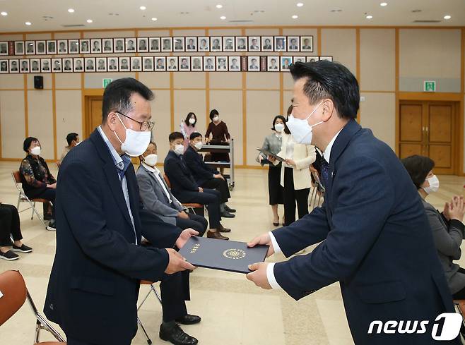 23일 박중근 충북 충주부시장(오른족)이 장애인 복지 증진을 위해 애쓴 장애인단체 관계자에게 표창을 전달하고 있다.(충주시 제공)2021.4.23/© 뉴스1