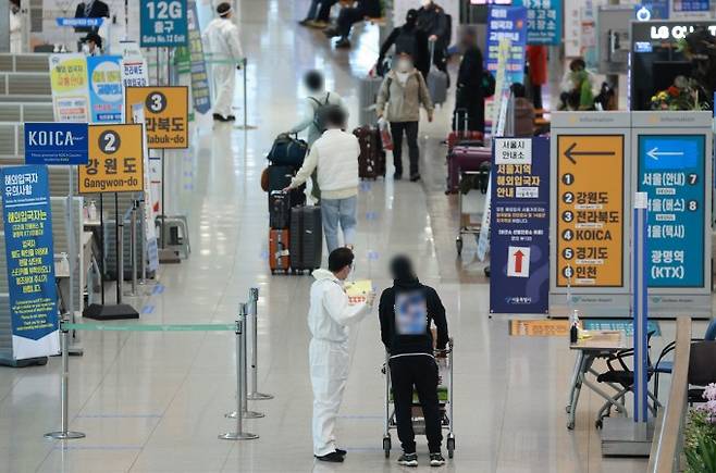 20일 인천국제공항 제1여객터미널 입국장에서 해외 입국자들이 방역절차에 따라 이동하고 있다. 연합뉴스 제공