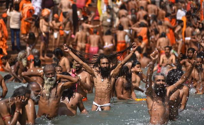 14일(현지 시각) 인도 북부 성지 하리드와르에서 힌두교 축제 '쿰브 멜라'를 맞아 힌두교도들이 갠지스강에 들어가 목욕을 하고 있다. 이날 하루 동안 135만명이 이곳에서 목욕을 했으며, 참석자의 대부분은 마스크를 하지 않았다고 외신들은 전했다. /EPA 연합뉴스