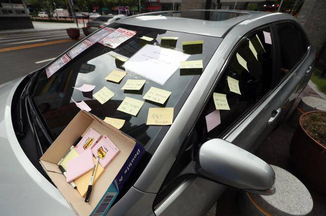 2018년 8월 29일 오전 인천시 연수구 모 아파트단지 정문 인도에 방치된 50대 여성 주민의 캠리 차량에 주민 불만이 적힌 쪽지들이 부착돼 있다. 이 여성은 아파트단지 주차위반 스티커가 부착된 것에 화가 나 자신의 승용차로 지하주차장 진입로를 막아 물의를 빚었다. 연합뉴스