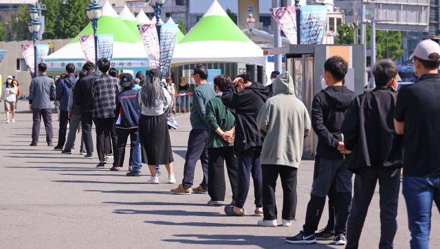 25일 오전 서울역광장에 마련된 코로나19 임시선별검사소를 찾은 시민들이 검체 검사를 위해 줄지어 서 있다. 연합뉴스
