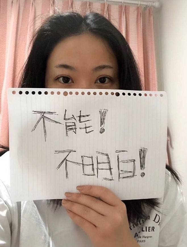 A Chinese woman holds a sign that reads, "can't do, don't know" to criticize the Chinese government's persecution of the late physician Li Wenliang, who was forced to say "can do" and "[I] know" when asked by the Chinese government to stop "spreading false news" and if Li knows his actions are criminal. (provided by Cum Libro)