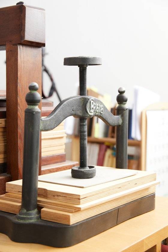 종이의 숨을 죽이고 온전하게 자리 잡을 수 있도록 종이나 책을 눌러주는 프레스 기계.