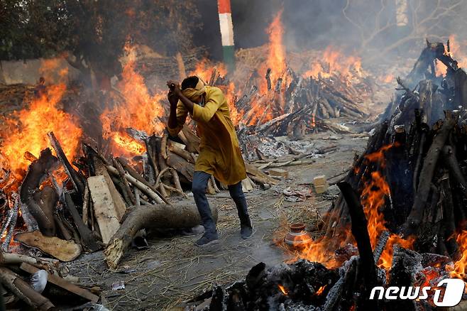 26일 인도 뉴델리의 한 화장장에서 한 남성이 불길을 피해 화장장을 나오고 있다. © 로이터=뉴스1 © News1 박형기 기자
