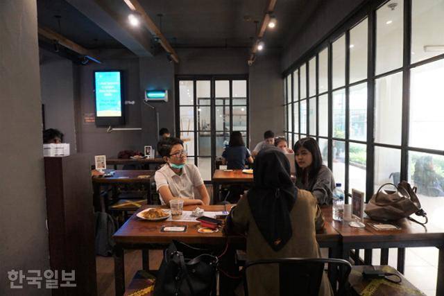 인도네시아 젊은이들이 자카르타 도심의 '와룽 압노르말'에서 미고랭을 주문한 뒤 대화하고 있다. 자카르타=고찬유 특파원