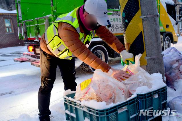 [광주=뉴시스] 김혜인 기자 = 광주 동구 용산동 한 주택가에서 환경 미화원이 재활용 안내문구를 부착하고 있다. 2021.02.18. photo@newsis.com