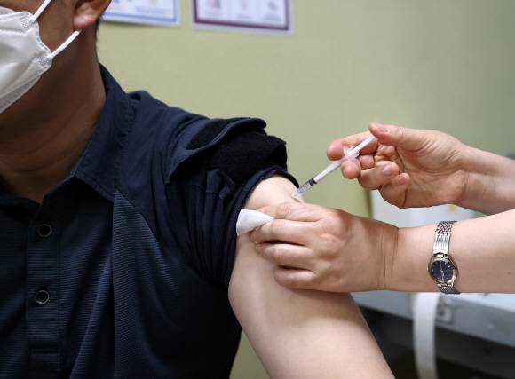 경찰·해양경찰·소방 등 사회필수인력에 대한 아스트라제네카(AZ) 백신 접종이 시작된 26일 종로구 서울적십자병원에서 경찰 관계자가 접종받고 있다. 2021. 4. 26 박지환 기자  popocar@seoul.co.kr