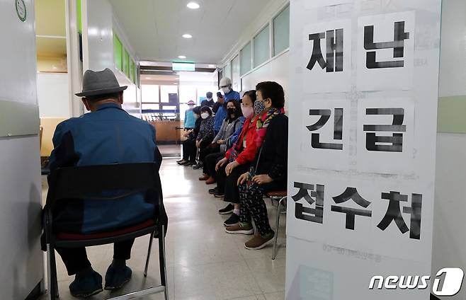 지난해 4월 서울시내 한 동주민센터를 찾은 주민들이 재난긴급생활비 접수를 위해 줄지어 기다리고 있다. 2020.4.16/뉴스1 © News1 박지혜 기자