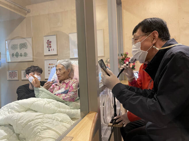서울 성동구 시립동부노인요양센터에 설치된 비대면 이동식 면회실 ‘가족의 거실’에서 지난달 말 한 가족이 면회 시간을 보내고 있다. 서울시 제공